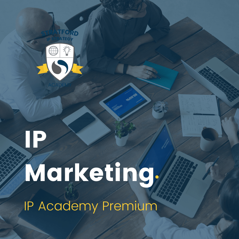 IP Strategy Academy lesson tile for IP marketing. Overhead view of several colleagues working at a desk filed with laptops, electronic devices and papers